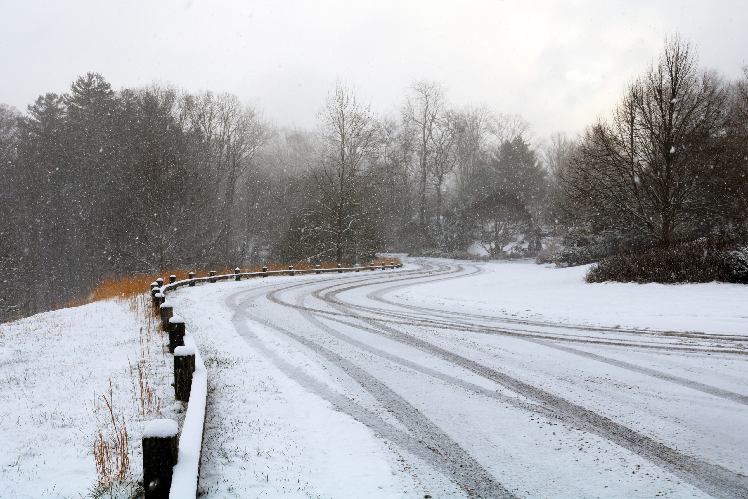 Tire tracks on an inclined road covered in snow and ice